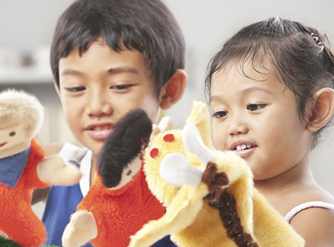 Sibling playing hand puppets, which were handmade