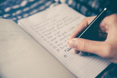 A person writing a checklist